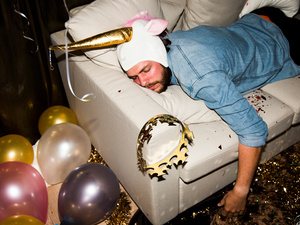 Illustration: Ein junger Mann liegt verkatert auf einer Couch.