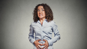 Eine Frau reagiert auf Bauchgrummeln (Symbolbild).