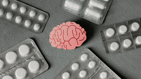 Das Modell eines Gehirns und verschiedene Tabletten (Illustration).