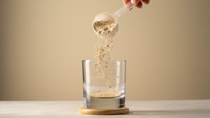Eine Person füllt mit einem Löffel Proteinpulver in ein Glas.