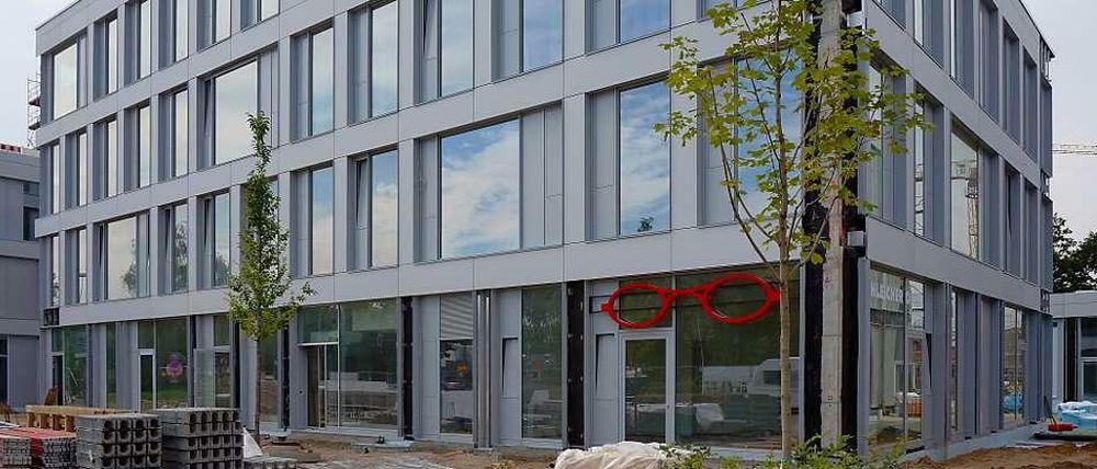 Farbwechsel. Nachdem die Baugerüste gefallen waren, zeigte sich im letzten Jahr, dass die Neubauten auf der alten Truman Plaza hellgrau statt elfenbein- oder sandfarben sind. Fand jedenfalls der Bezirk und zoffte sich mit dem Investor. Der sagt jetzt: "Wir wollen Frieden."