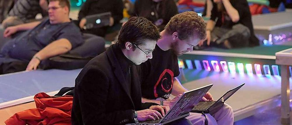 Teilnehmer des 28. Jahreskongresses des Chaos Computer Clubs im Berliner Congress Center (BCC) in Berlin an ihrem Laptops.