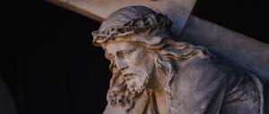 Eine Figur des Jesu Christi mit dem Kreuz an einer Fassade in der Bamberger Altstadt.