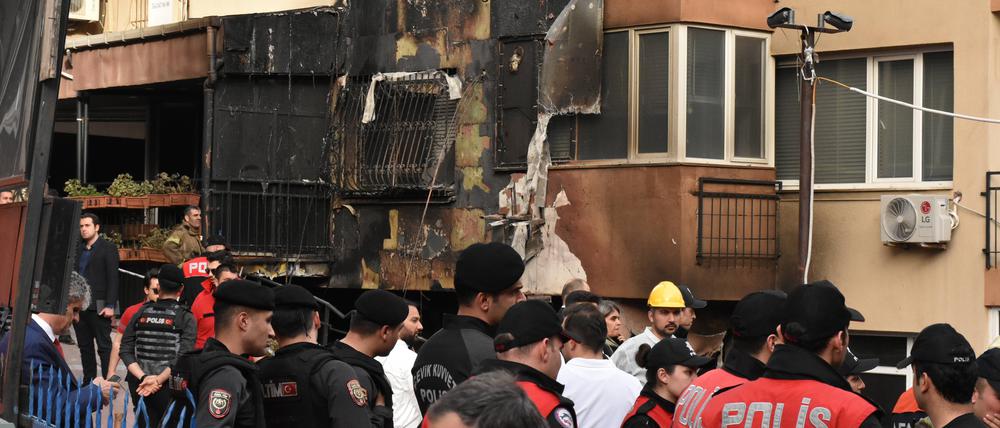 Police forces stand in front of the partly burnt building after a fire eruption in Istanbul.