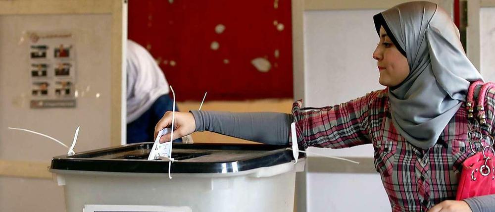 Eine junge Frau gibt ihre Stimme an der Urne ab.