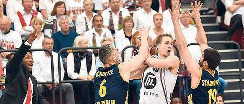 Hände hoch! Die Alba-Spieler Sven Schultze und Vojdan Stojanovski umzingeln Quakenbrücks Chad Topper, auch Quakenbrücks Trainer Tyron McCoy (links) streckt sich.