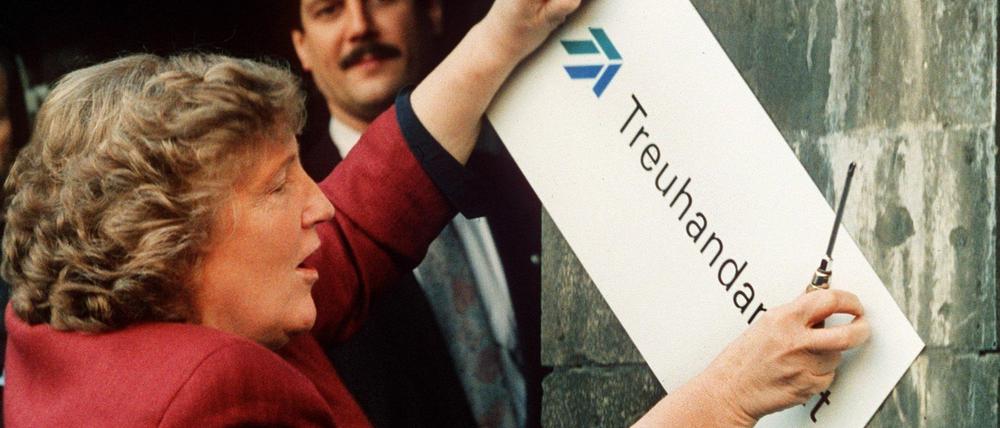 Die scheidende Treuhand-Präsidentin Birgit Breuel entfernt am 30.12.1994 eigenhändig mit einem Schraubenzieher das Firmenschild am Eingang der Treuhandanstalt in Berlin. Auf die Treuhand wurde viel eingedroschen. Doch das war gewollt, wie ein neues Buch des Hamburger Autor Dirk Laabs über das wohl dunkelste Kapitel der Wiedereinigung zeigt. Die Superbehörde diente Bundesregierung und Wirtschaftskonzernen als Sündenbock beim Ausverkauf der DDR.