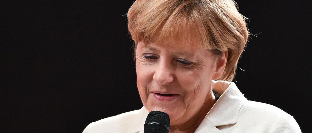 Angela Merkel hält bei der Eröffnung der Internationalen Automobilausstellung IAA in Frankfurt am Main ein Miniaturmodell des neuen Opel Astra in den Händen.