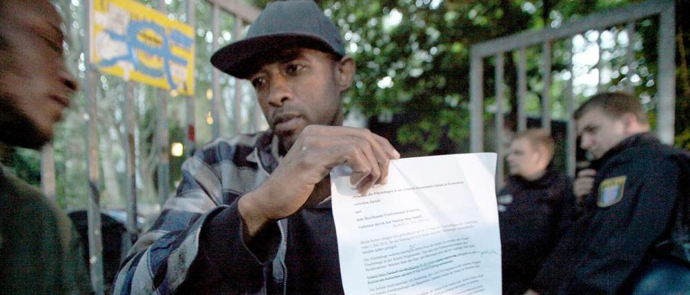 Ein Papier mit Folgen. Ein Flüchtling präsentiert im Juli 2014 die Vereinbarung mit dem Bezirksamt Friedrichshain-Kreuzberg zur Gerhart-Hauptmann-Schule.