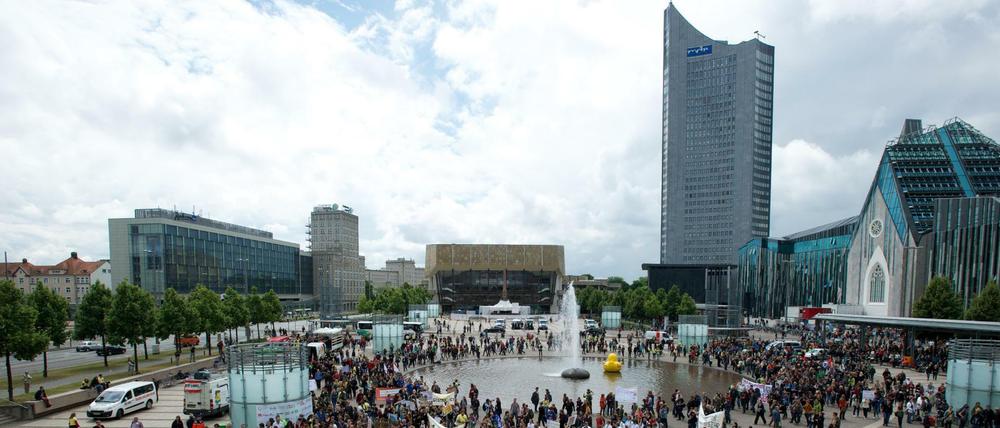 Studierende stehen mit Transparenten auf einem Platz und protestieren.