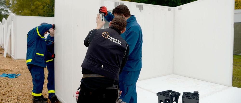 Mitarbeiter des technischen Hilfswerks (THW) bauen in der Flüchtlingsnotunterkunft Scheuen bei Celle neue Schnellbauhütten auf.