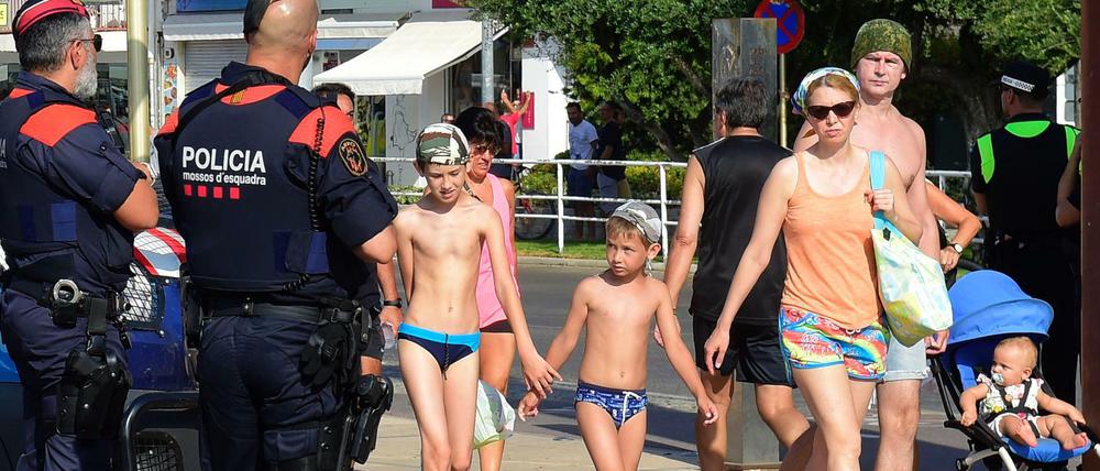 Die Polizei patrouilliert, Badegäste spazieren vorbei. Ein Bild aus Cambrils am Freitag.