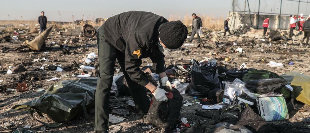 Detailarbeit: Ein Mann durchsucht die Trümmer an der Absturzstelle bei Teheran.