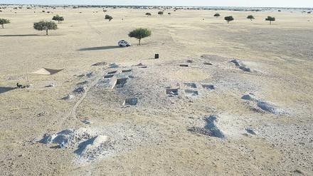 Drohnenbild einer archäologischen Grabungsstätte in einer kargen afrikanischen Landschaft.