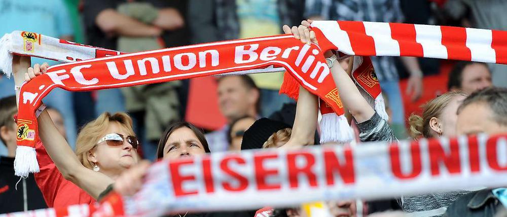 Union-Fans halten ihre Schals hoch.