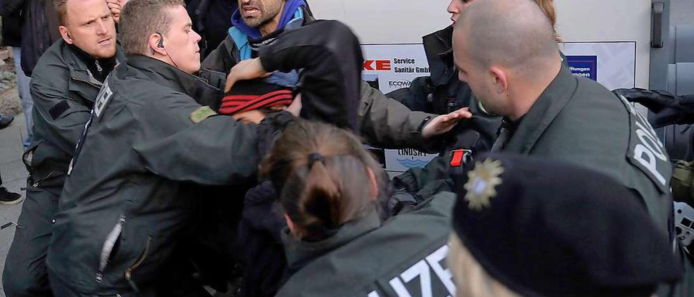 Polizisten tragen einen Demonstranten gegen einen Aufmarsch der rechtsextremen NPD am Freitag in Berlin von der Marienfelder Allee.