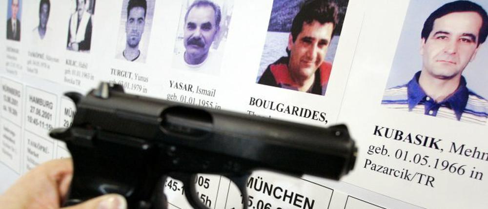 Die baugleiche Tatwaffe der sogenannten "Döner-Morde" vor einem Plakat mit Porträts der Opfer.