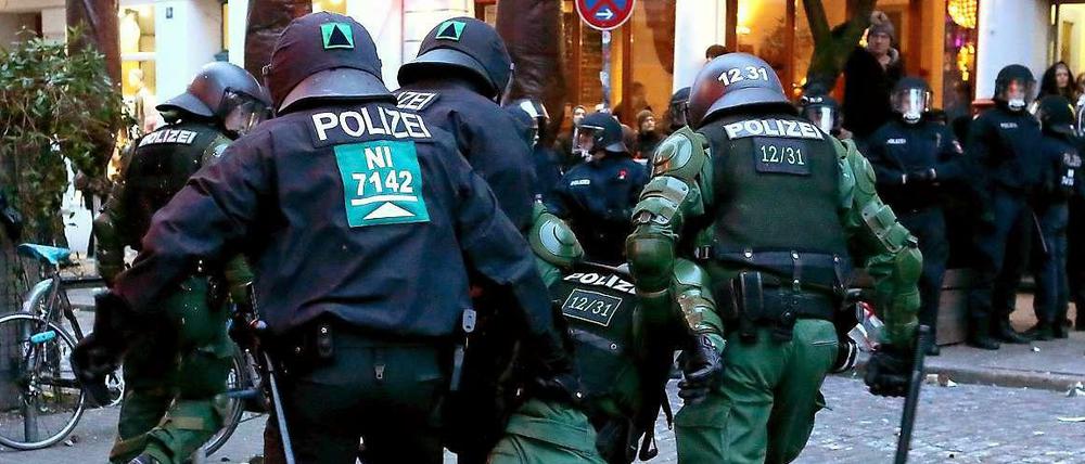 Polizisten tragen einen verletzten Kollegen bei Ausschreitungen im Hamburger Schanzenviertel.
