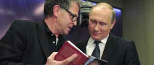 Hubert Seipel und der russische Präsident Wladimir Putin schauen gemeinsam in eines von Seipels Büchern.