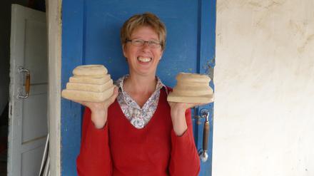 Gunvor Lindström von der Eurasien-Abteilung des Deutschen Archäologischen Instituts (DAI) am Grabungshaus in Torboluk (Tadschikistan) mit zwei baktrischen Miniaturaltären, die sie dort ausgegraben hat.