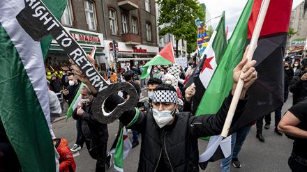 Ein Teilnehmer der Demonstration verschiedener palästinensischer Gruppen läuft und einem großen Schlüssel mit der Aufschrift „Right to Return“ durch Neukölln.