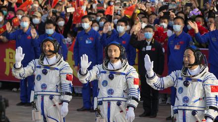 Die chinesischen Astronauten der Shenzhou-16-Mission, Gui Haichao (l-r), Zhu Yangzhu und Jing Haipeng, winken bei einer Abschiedszeremonie vor ihrer bemannten Weltraummission im Jiuquan Satellite Launch Center.