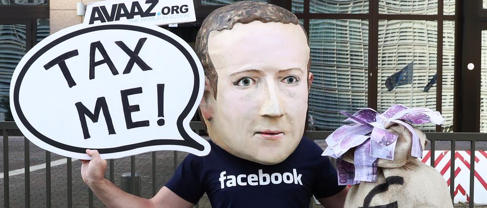 Mark Zuckerberg soll in Europa Steuern zahlen. Dafür setzt sich ein Demonstrant in Brüssel ein.