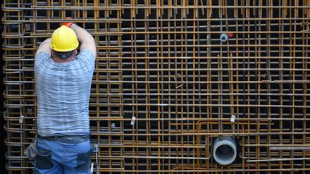 Ein Bauarbeiter ist in Dresden mit einer Stahlbetonwand beschäftigt.