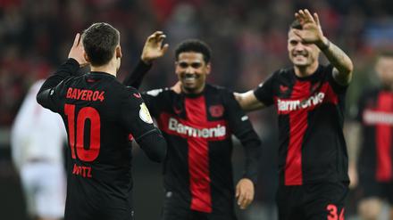 Leverkusens Florian Wirtz (l-r), Leverkusens Amine Adli und Leverkusens Granit Xhaka jubeln nach dem Tor zum 3:0.