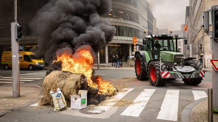 Bei Protesten anlässlich eines Treffens der EU-Agrarminister in Brüssel zünden Landwirte Strohballen an.