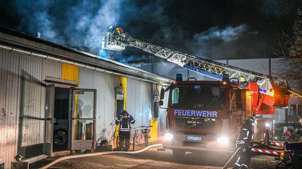 Mitarbeiter der Feuerwehr löschen einen Brand in einer Asylbewerberunterkunft. 