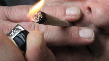 Ein Mann raucht eine selbst gedrehte Cannabis-Zigarette. (Symbolfoto)