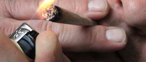 Ein Mann raucht eine selbst gedrehte Cannabis-Zigarette. (Symbolfoto)