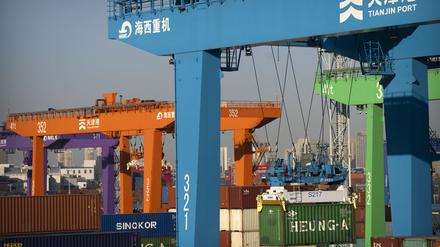 Ein Kran hebt einen Schiffscontainer in einem automatisierten Containerhafen in Tianjin. Vor dem Hintergrund der chaotischen Corona-Lage in China ist die Wirtschaft des Landes nach offiziellen Angaben im vierten Quartal noch um 2,9 Prozent gewachsen.