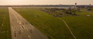 Menschen sind während des Sonnenuntergangs auf dem Tempelhofer Feld unterwegs, Symbolbild.