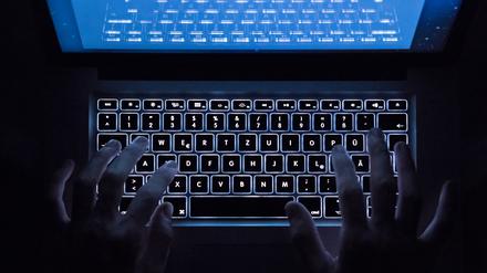 Eine potenzielle Hacker:in, die über den privaten Laptop versucht, Cyberbarrieren zu umgehen, um wirtschaftlichen Schaden zu verursachen.