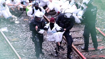 Ein Klimaschutzaktivist der Gruppe „Ende Gelände“ wird vor dem Kraftwerk Scholven von Polizisten weggetragen.