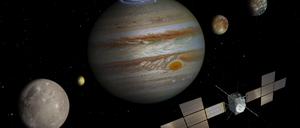 Eine Illustration zeigt „Juice“ vor dem Jupiter (Mitte) und seinen vier Eismonden (von links): Ganymed, Io, Europa und Kallisto. Drei wird die Sonde erkunden.