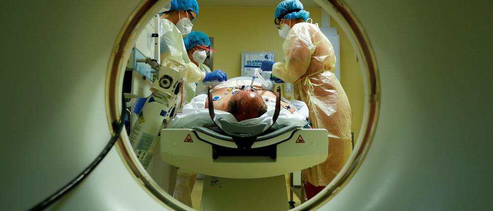 FILE PHOTO: Members of the medical staff in protective suits treat a patient suffering from the coronavirus disease (COVID-19) with a computer tomograph in the Intensive Care Unit (ICU) at Havelhoehe community hospital in Berlin, Germany, October 30, 2020. REUTERS/Fabrizio Bensch/File Photo