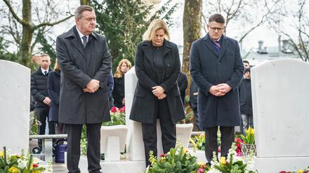 Claus Kaminsky (SPD, l-r), Oberbürgermeister von Hanau, Nancy Faeser (SPD), Bundesinnenministerin, und Boris Rhein (CDU), Ministerpräsident von Hessen, stehen auf dem Hanauer Hauptfriedhof zwischen Gräbern der Opfer. 