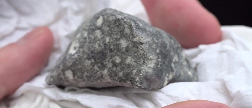 Ein mutmaßliches Meteoritenteil liegt in einem Papiertaschentuch. Das Bruchstück wurde von vier polnischen Meteortitensuchern auf einem Feld bei Ribbeck gefunden. 