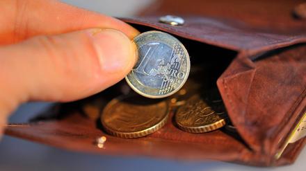 Eine Hand nimmt am 22.01.2010 eine Euro-Münze aus einem Geldbeutel, in dem sich weitere Münzen befinden. 