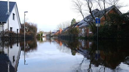 Eine Straße in einem Wohngebiet in Lilienthal steht unter Wasser. Hier ist die Wümme über die Ufer getreten. Die Anwohnerinnen und Anwohner des Ortes können ihre Häuser nur noch mit Booten erreichen. 