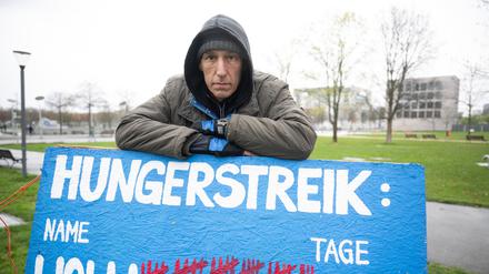 Aktivist Wolfgang Metzeler-Kick, der sich seit dem 7. März im Hungerstreik befindet, steht in einem Zeltlager im Spreebogenpark hinter einem Schild, auf dem die Anzahl seiner Tage im Hungerstreik markiert ist