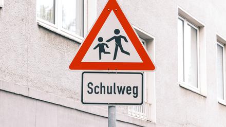 Ein Verkehrsschild warnt zum Langsamfahren vor einem Schulweg.