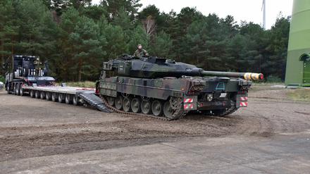 Ein Kampfpanzer Leopard 2 wird auf einen Schwerlasttransporter verladen. 
