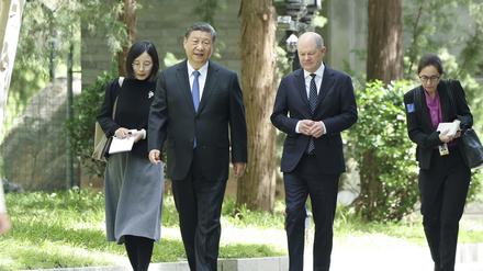 Der chinesische Präsident Xi Jinping und Bundeskanzler Olaf Scholz (SPD, 2.v.r.) gehen am Rande ihres Treffens zusammen ein paar Schritte.