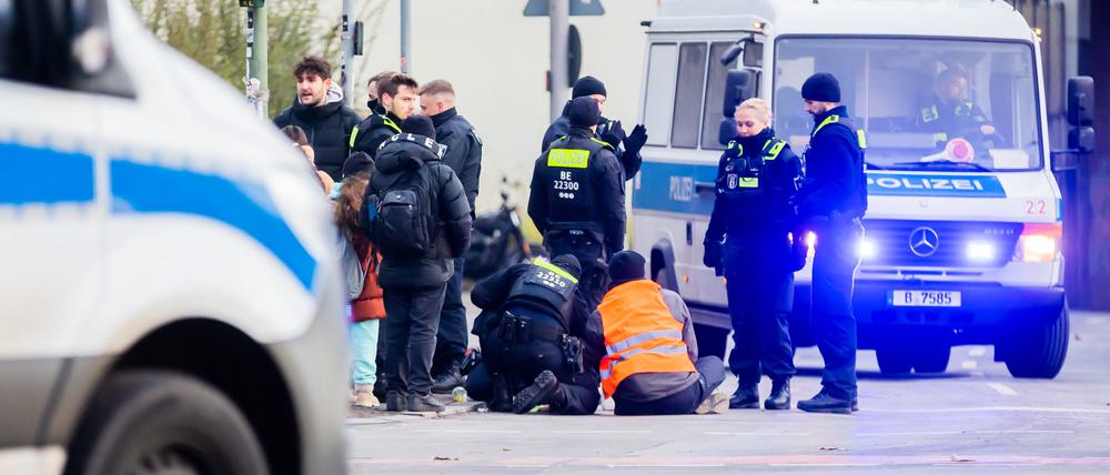 Ein Klima-Aktivist, der Mitte Dezember seine Hand auf einer Autobahnausfahrt am Innsbrucker Platz festgeklebt hat, wird von Polizisten losgelöst.