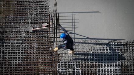 Berlin: Ein Arbeiter ist auf einer Baustelle am Alexanderplatz beschäftigt.