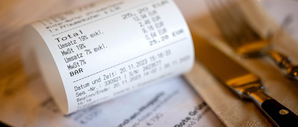 Eine Rechnung mit Umsatzsteuer und Mehrwertsteuer liegt auf der Speisekarte eines Restaurants. (Symbolbild)